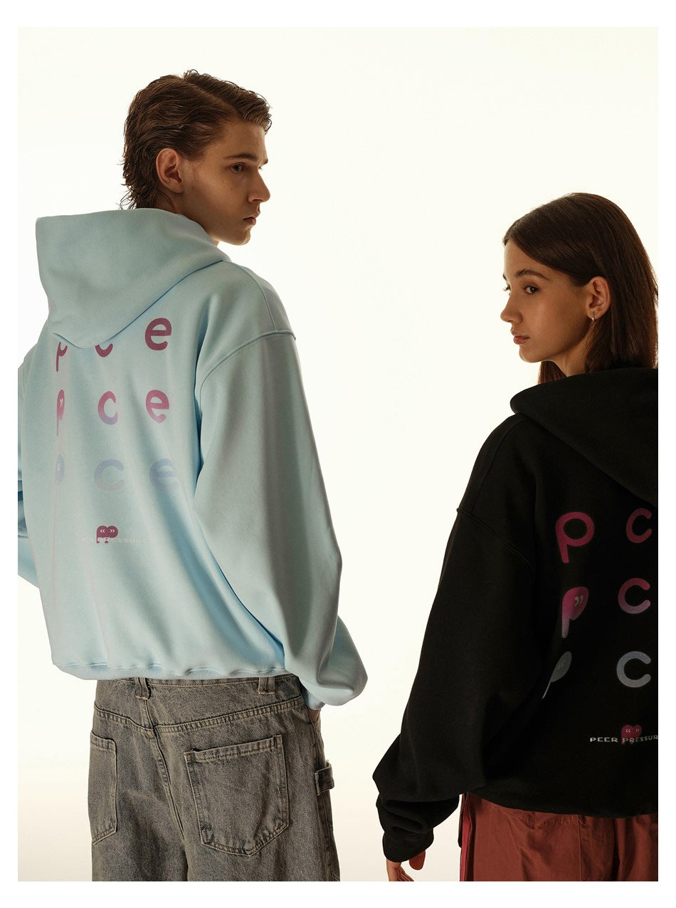 Two models look back in light blue and black hoodies, showing colorful lettering across their backs.