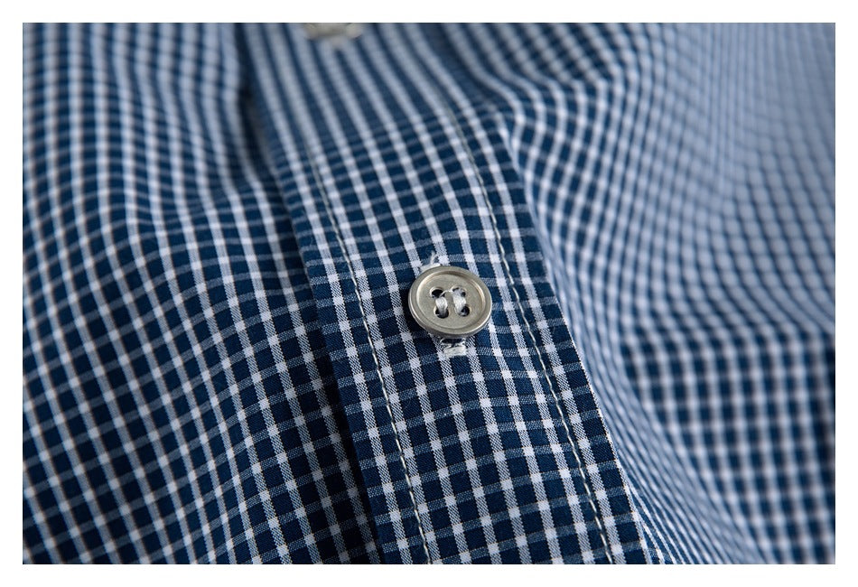 Close-up of a light button on the placket of a navy-and-white gingham shirt.
