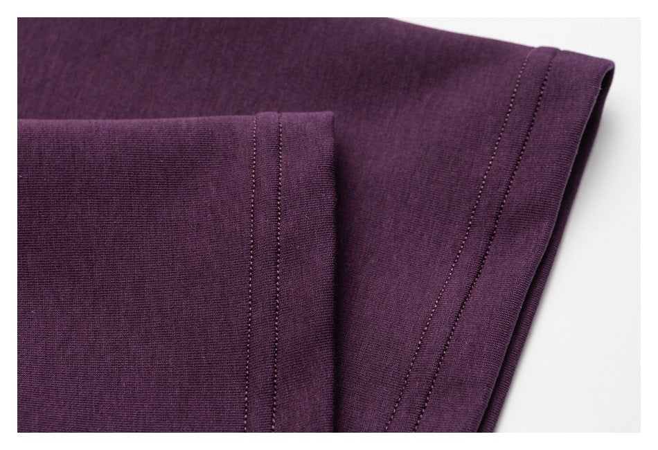 Close-up of the plum shirt's folded sleeve edge and stitched hem.
