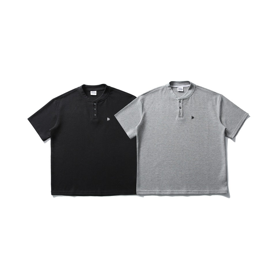 Black and light gray short-sleeve henley shirts shown from the front, each with a small chest mark.