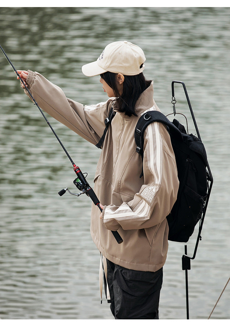 Side view of a model wearing a taupe striped-sleeve pullover jacket while fishing.