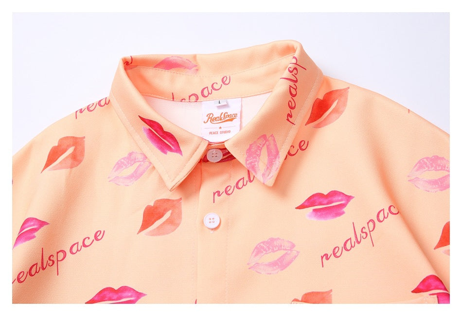 Close-up of the peach shirt's pointed collar, buttons, lipstick print, and sewn-in neck label.
