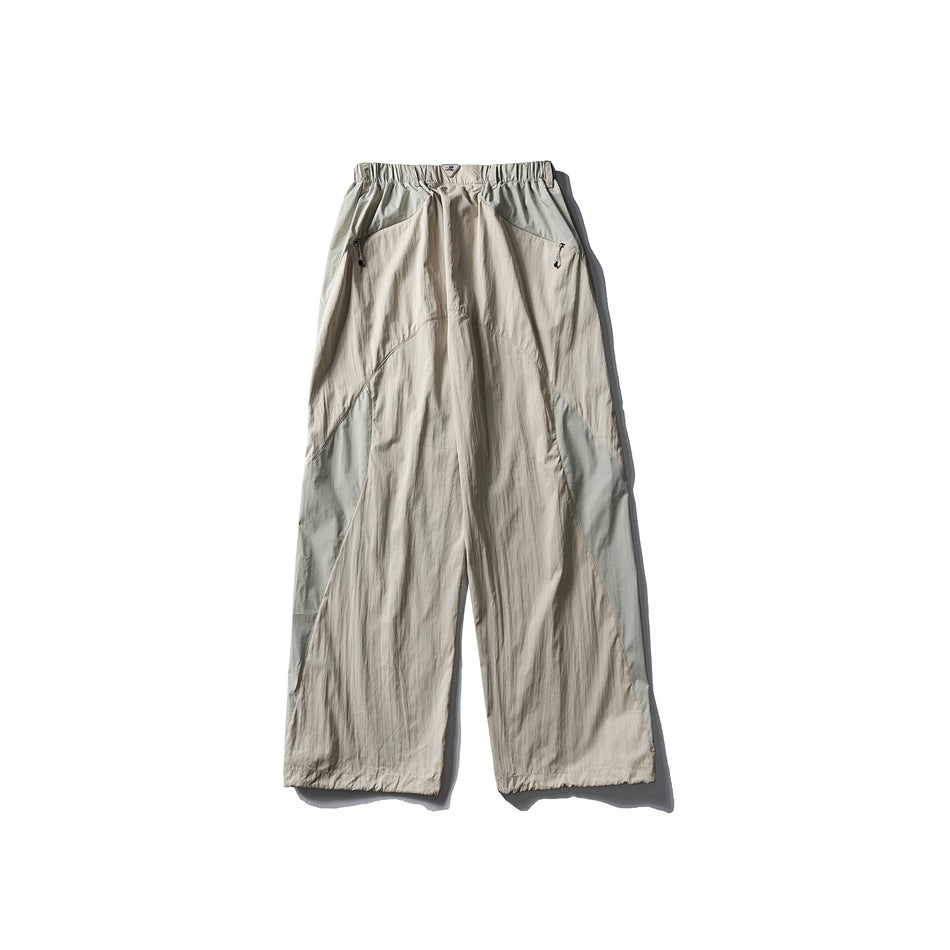 Cream wide-leg pants with sage green contrast panels, elastic waist and zip pockets, flat lay back view