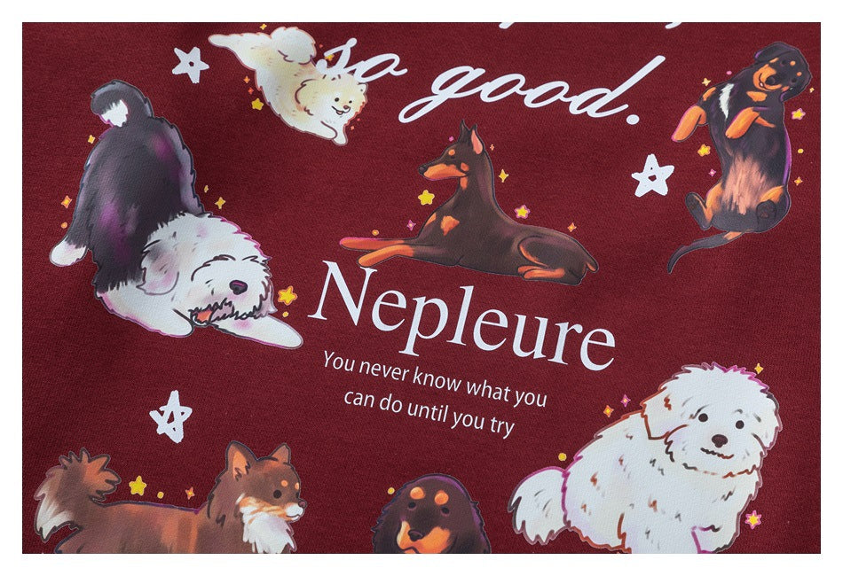 Detailed view of the sweatshirt's colorful dog-and-star graphic with English lettering on burgundy fabric.