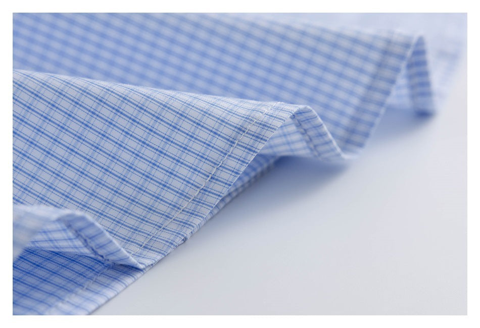 Close-up of a folded, stitched edge on a light blue fine-check shirt.