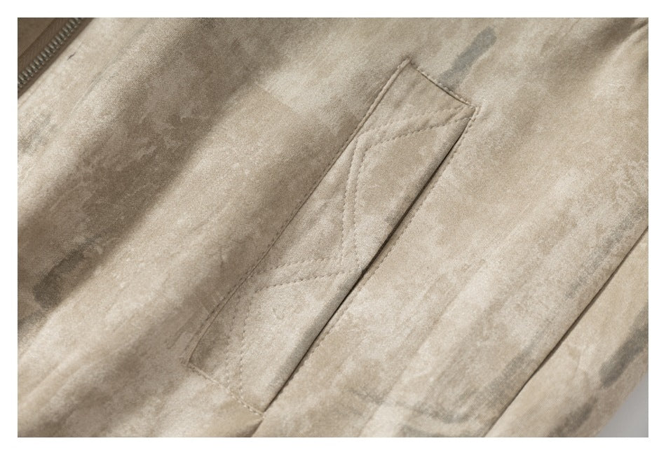 Close-up of a slanted welt pocket on the beige mottled jacket.