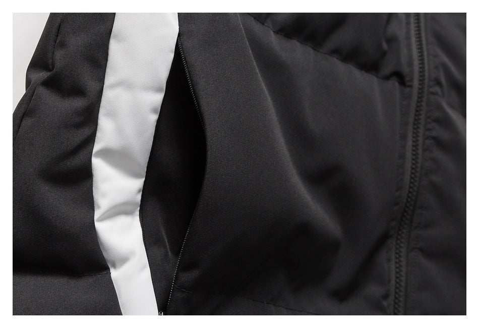 Close-up of a black garment with a white side panel, zippered pocket, and front zipper.