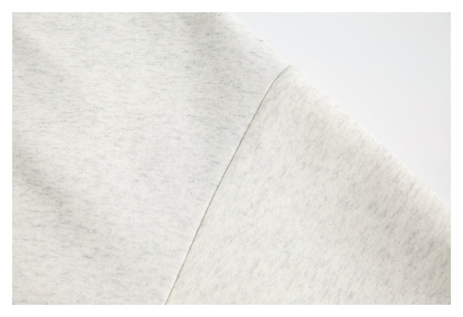 Close-up of a plain seam on light gray heather fabric.