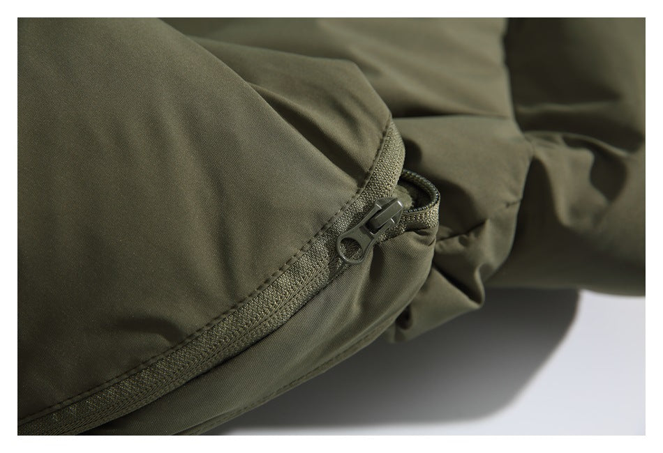 Close-up of a dark zipper and stitched seam on an olive-green padded garment.