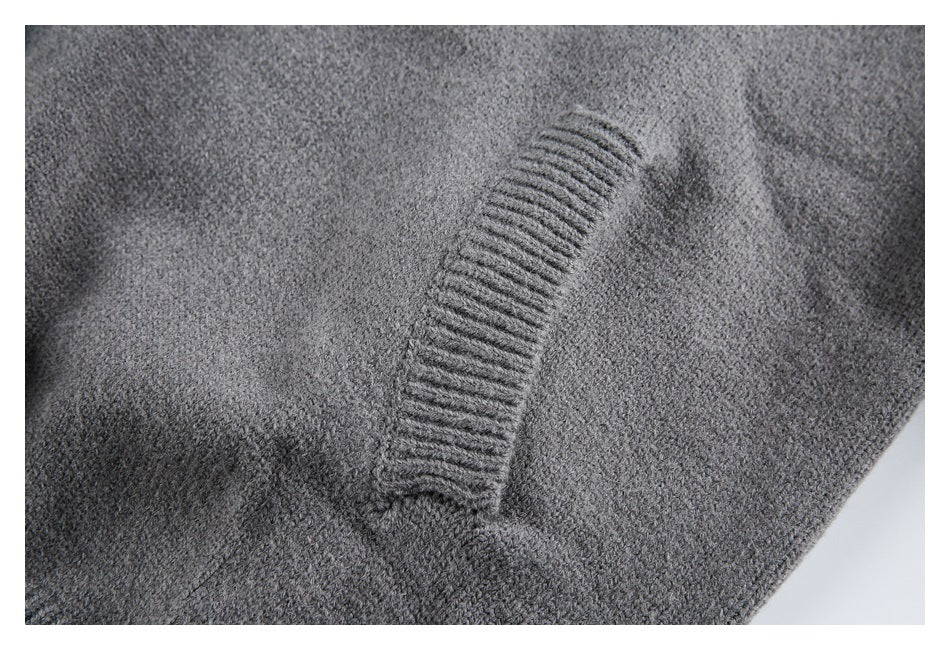 Close-up of a charcoal gray knit cardigan showing a ribbed seam against the textured knit.
