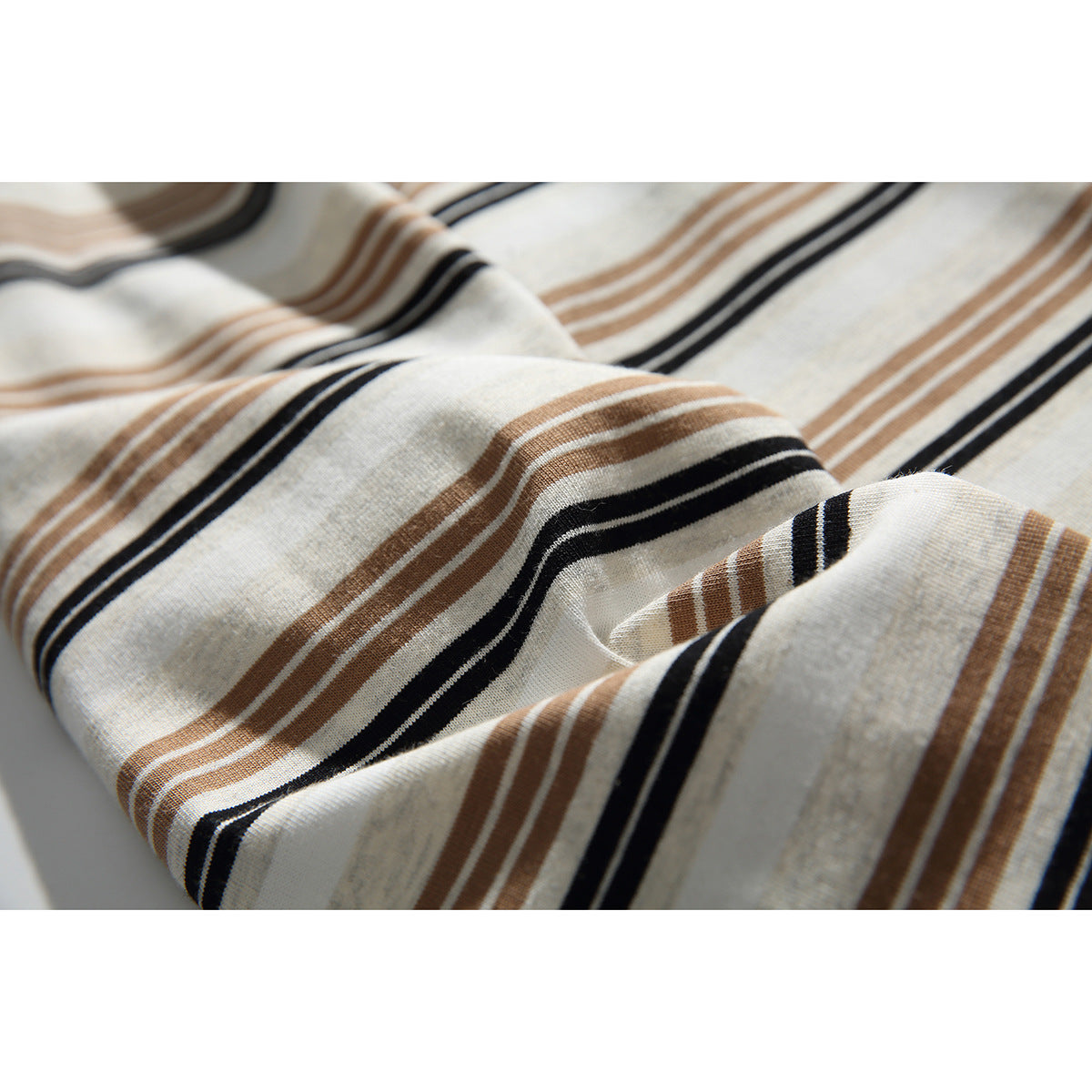 Close-up showing the ivory shirt fabric's tan and black horizontal stripe pattern.