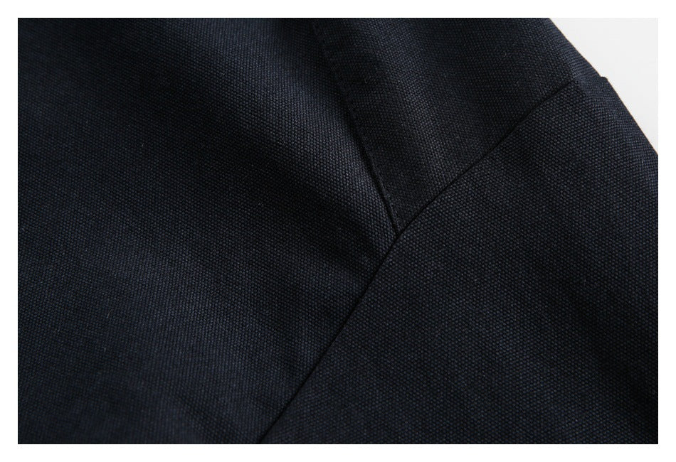 Close-up of dark navy fabric with a fine woven texture and curved seam.