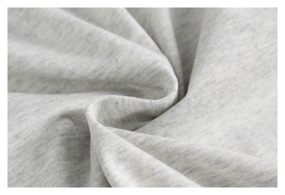 Close-up of light gray heathered knit fabric draped in soft folds.