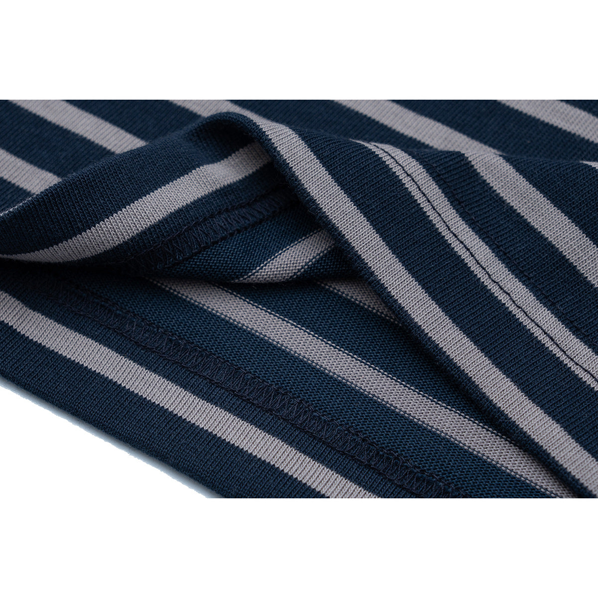 Close-up of navy and gray striped fabric showing a folded edge and stitched seam.