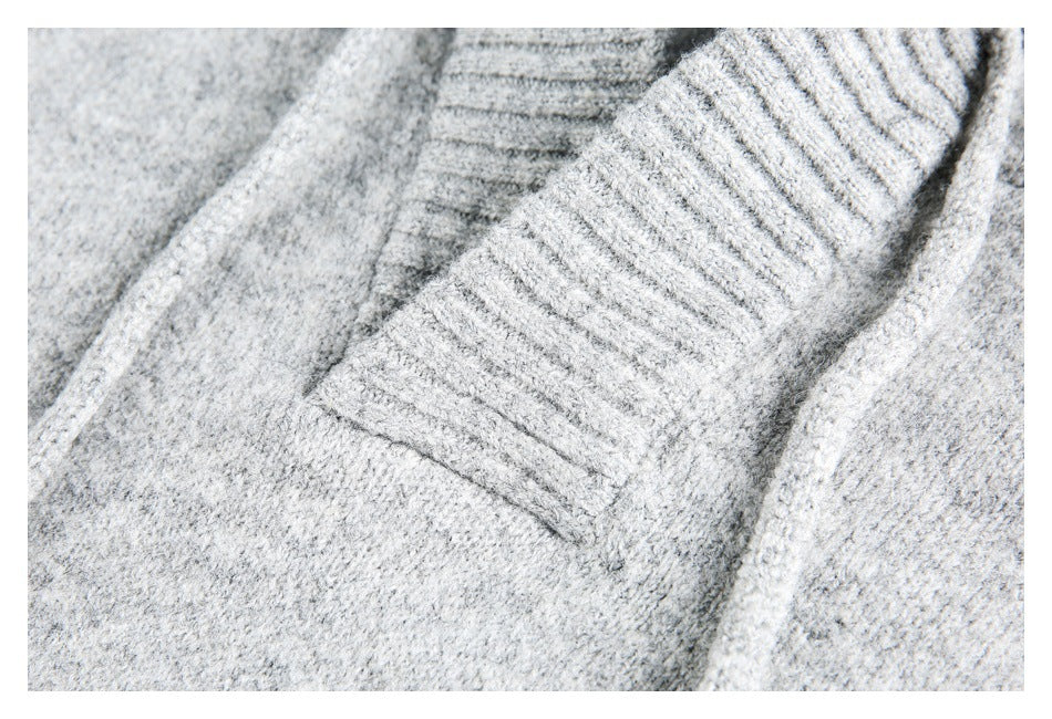 Close-up of light gray knitwear with a wide ribbed trim.