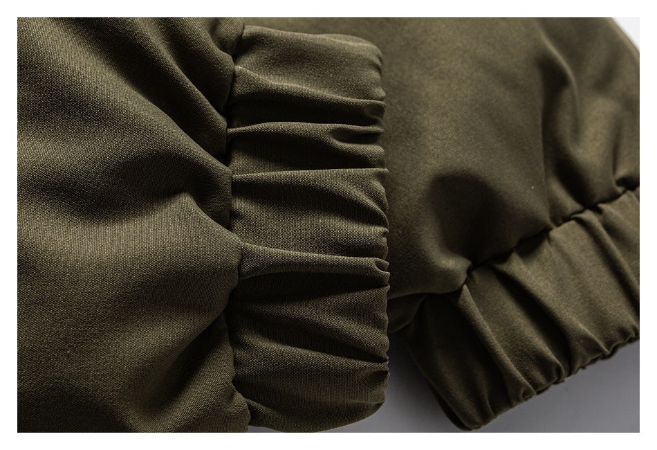 Close-up of olive garment fabric with a gathered elastic cuff or edge.