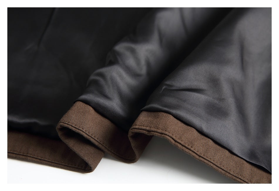 Close-up of a brown garment hem with dark lining folded back.