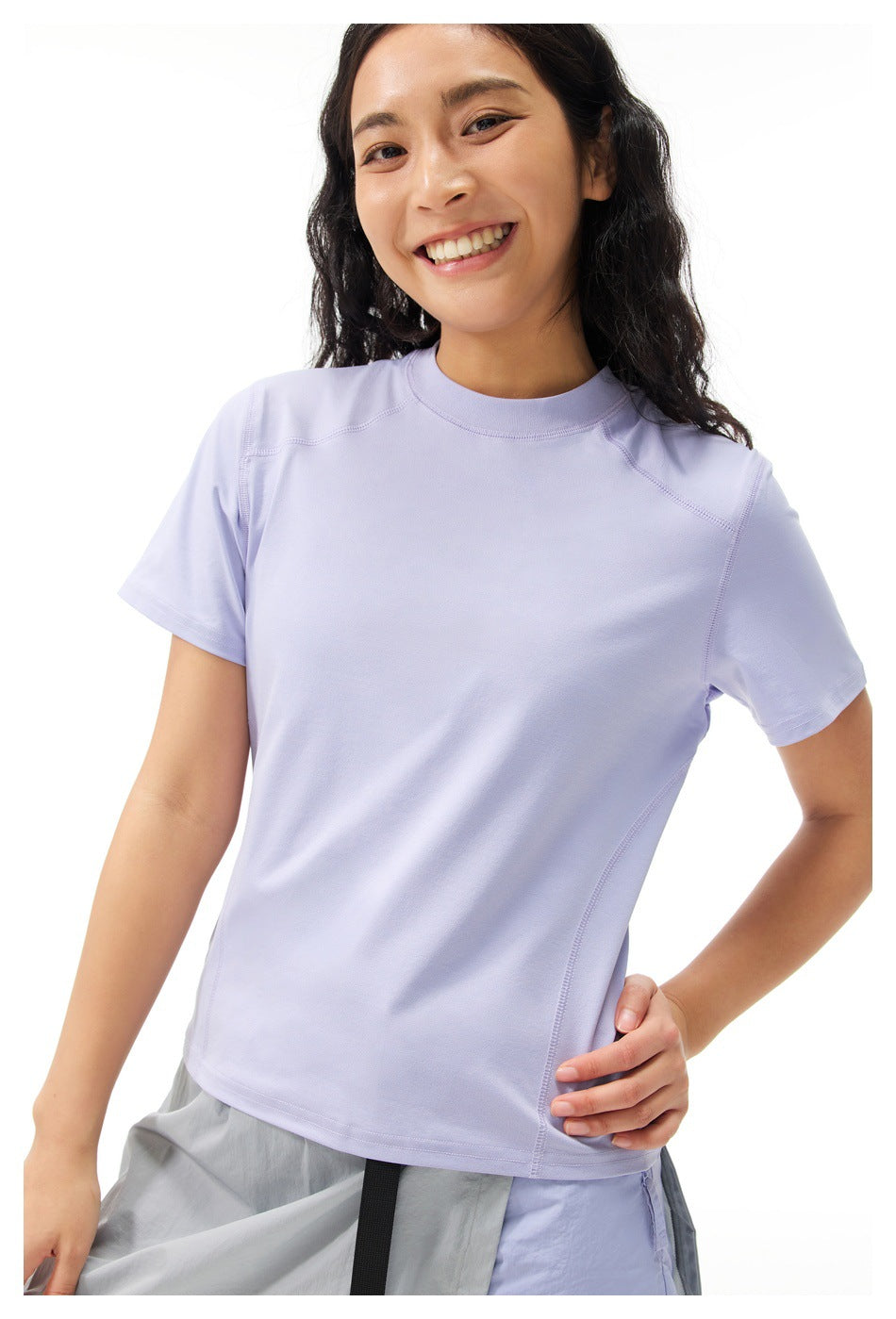 Close front view of a model wearing a lavender short-sleeve athletic T-shirt with curved seam details.