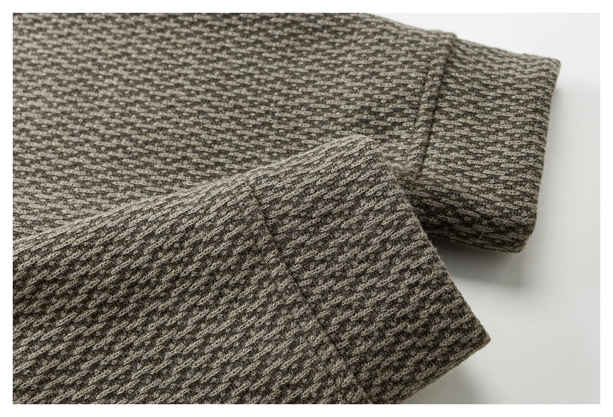 Close-up of a folded cuff on gray-brown textured fabric.