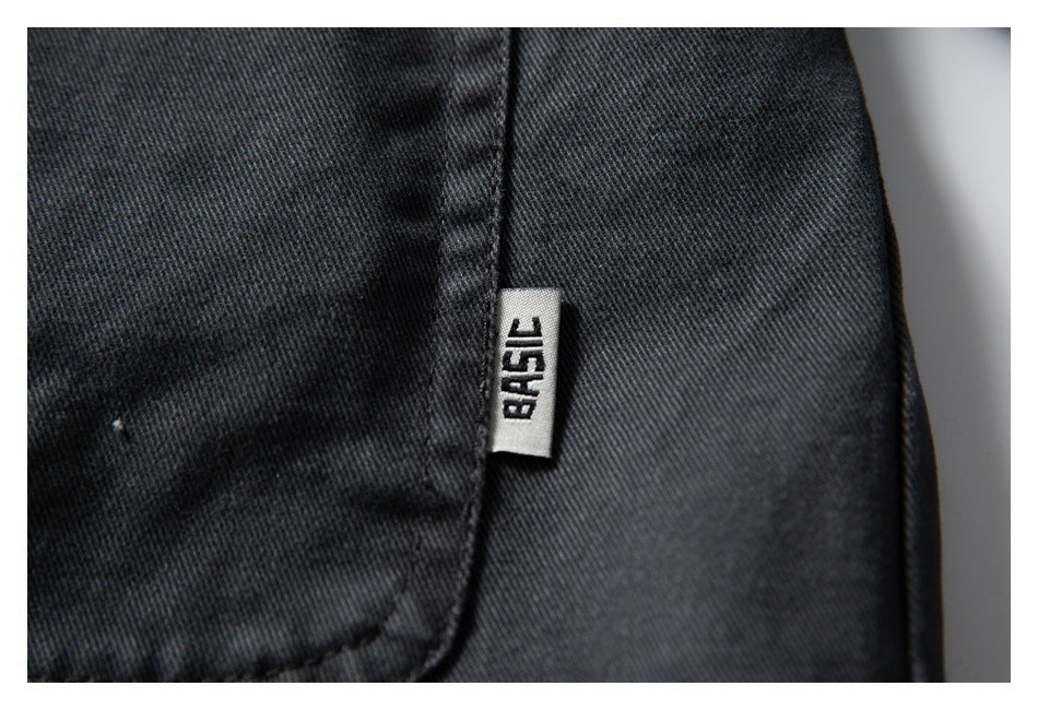 Close-up of dark charcoal fabric with a small white sewn tag bearing black lettering.
