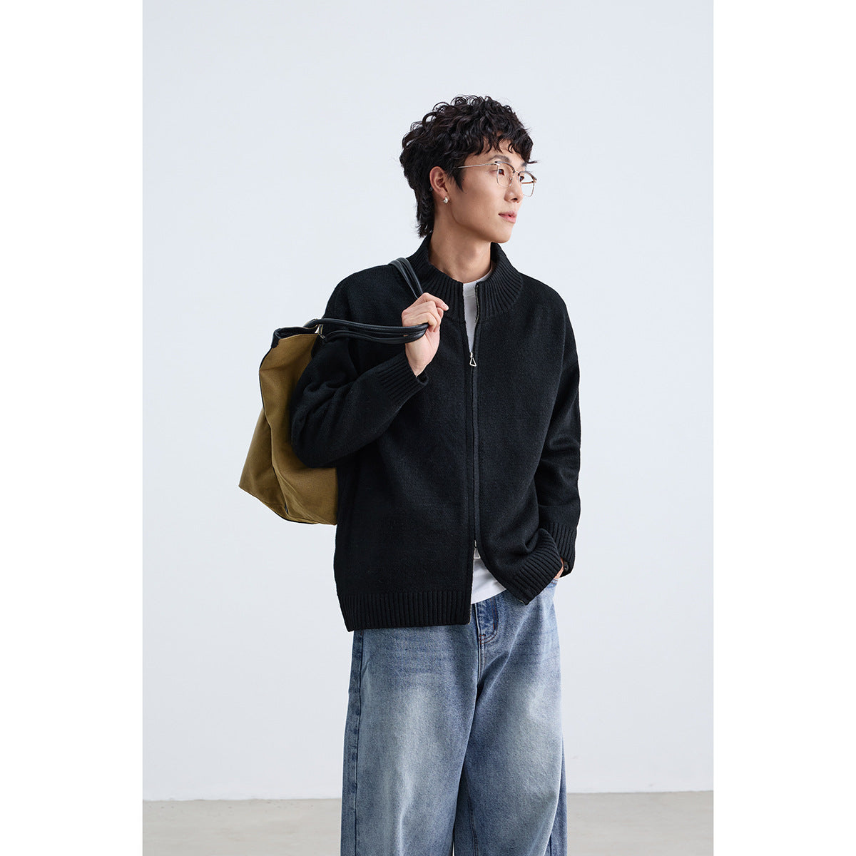 Model wearing a black zip-front cardigan with a ribbed stand collar, cuffs, and hem.
