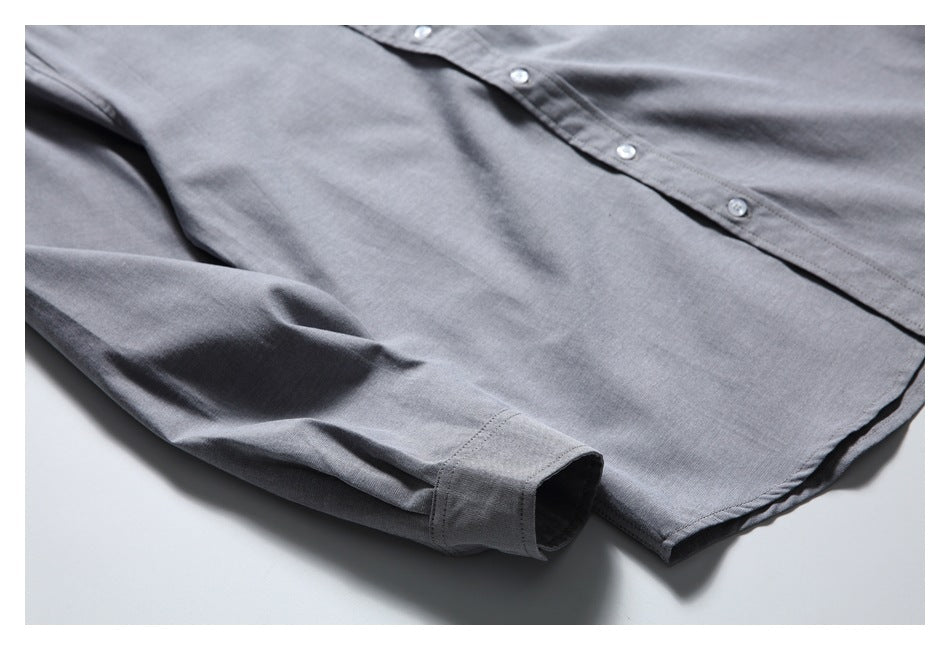 Partial flat lay of a gray long-sleeve button-up shirt, showing its front, placket, sleeve, and cuff.