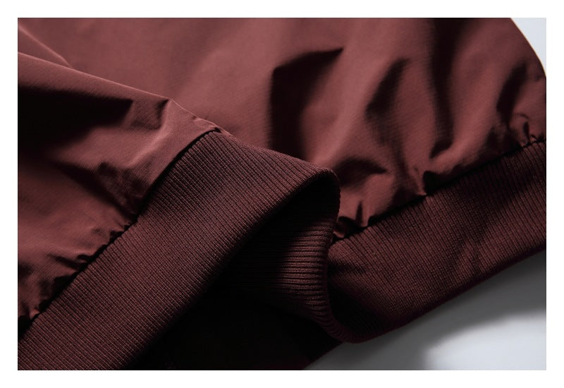 Close-up of the burgundy jacket's ribbed hem and gathered fabric.