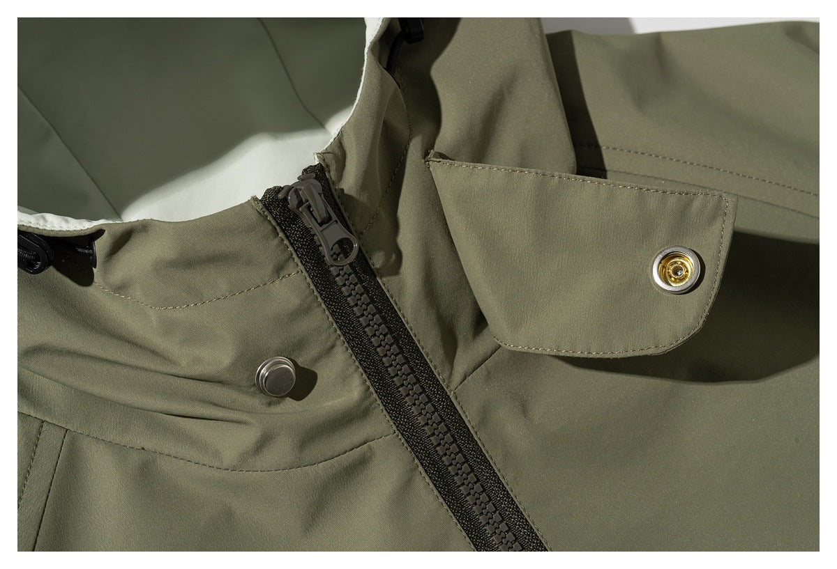Close-up of an olive jacket's front zipper and snap-fastened collar flap.