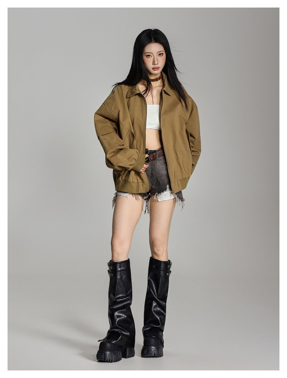 Full-length view of a model wearing an open oversized tan-brown jacket with a pointed collar and zip front.