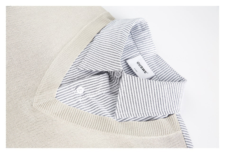 Close-up of the beige vest's ribbed V-neck layered over a striped shirt collar and visible neck label.