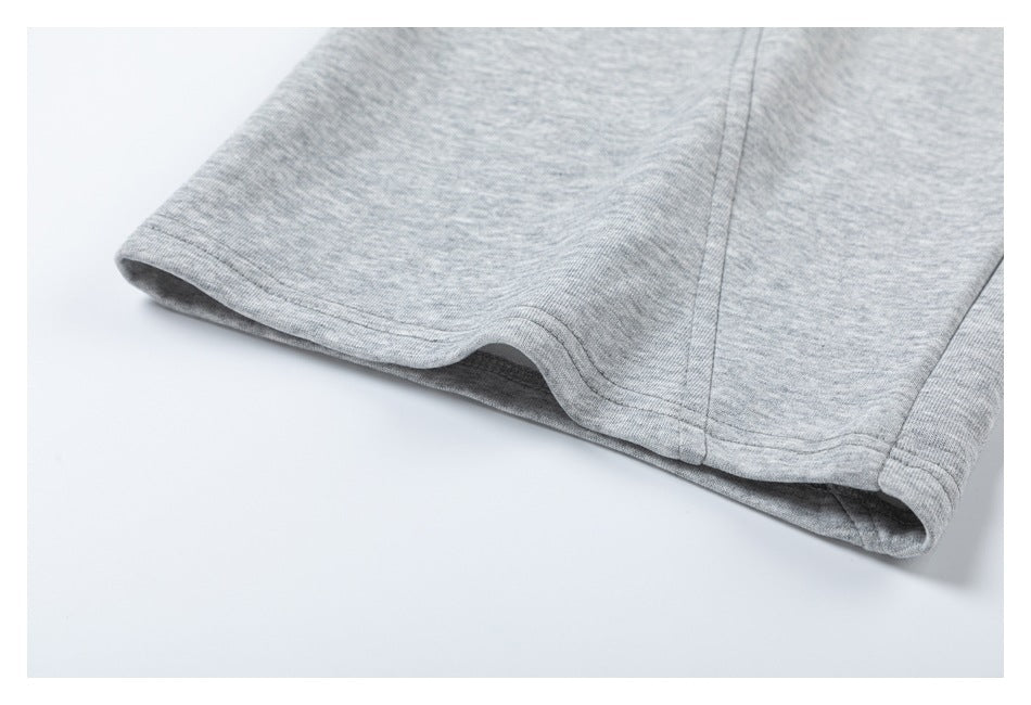 Close-up of the stitched hem on light gray heathered shorts.