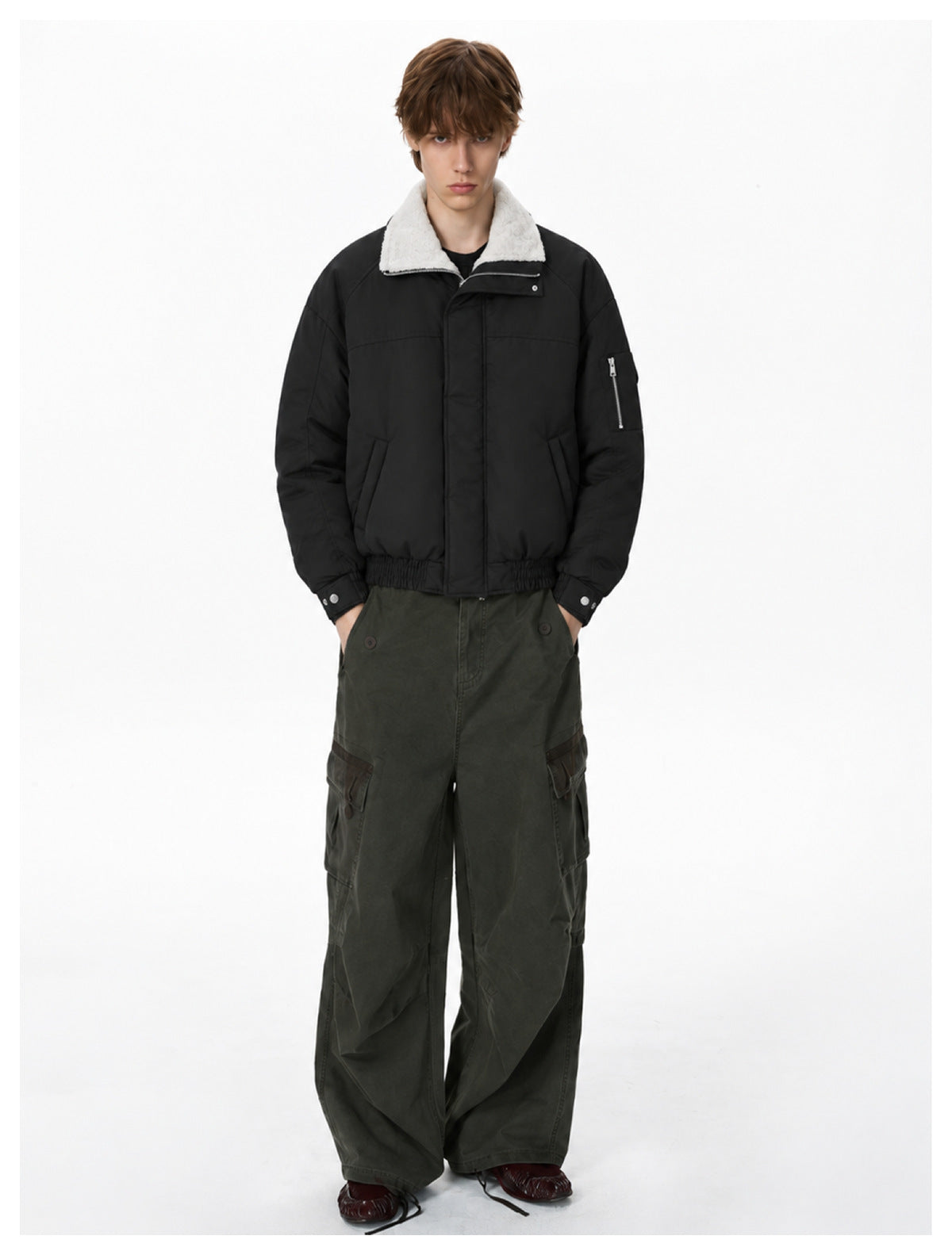 Model wearing the black padded bomber jacket with folded white fleece-like collar, with olive cargo pants