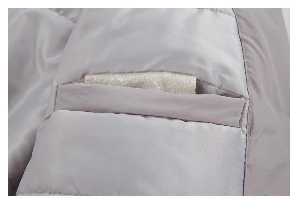 Close-up of a light gray jacket's inner pocket with a cream fabric piece tucked inside.