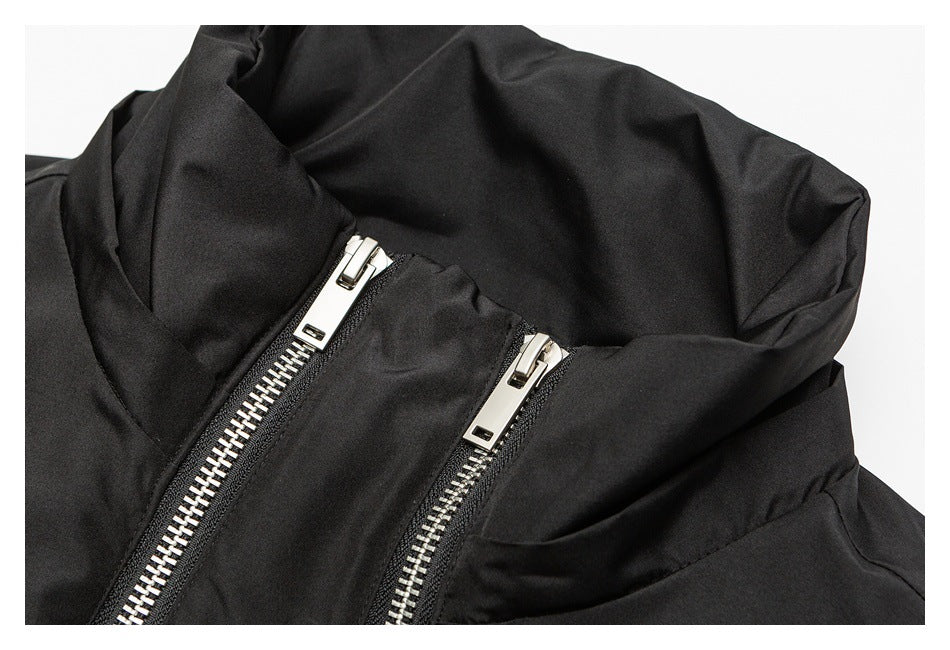 Close-up of a black garment with two silver zippers near a folded collar.