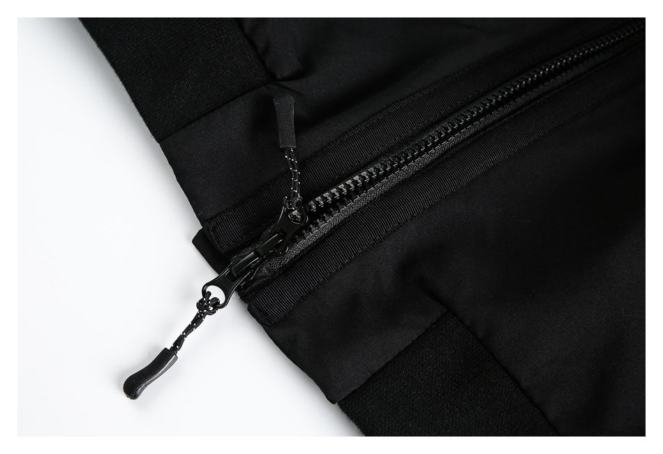 Close-up of a black garment zipper with two pull tabs and adjacent fabric panels.