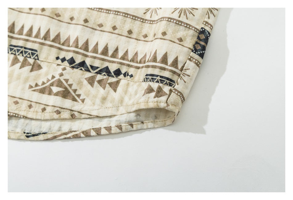 Close-up of the stitched hem and corner of a beige garment with brown and navy geometric patterns.