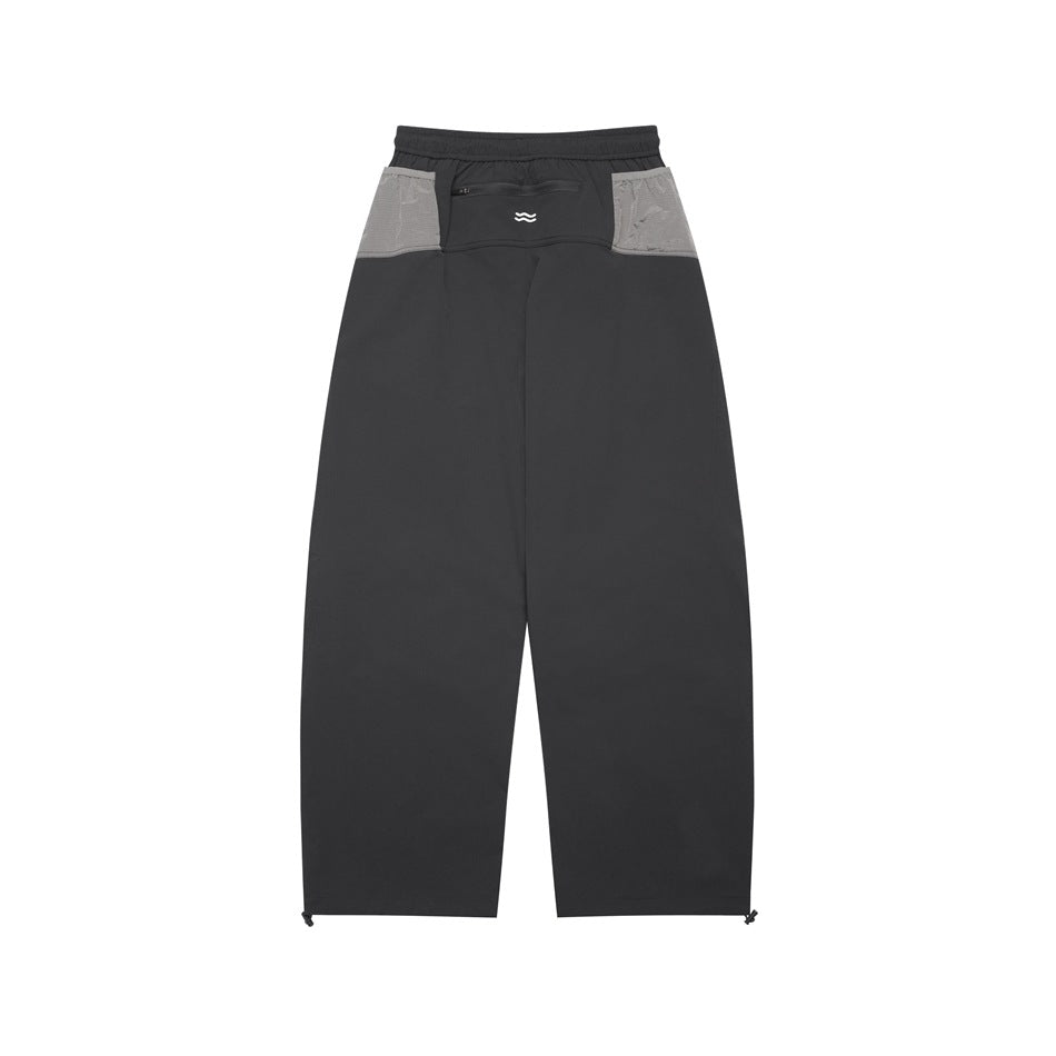 Full-length rear view of charcoal pants with light gray contrast panels, an elastic waistband, and a small zip pocket.