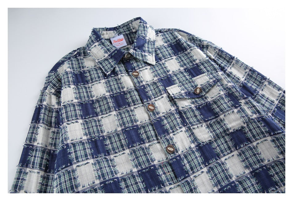 Angled close-up of a navy and white frayed plaid shirt showing its collar, buttons, and chest pocket.