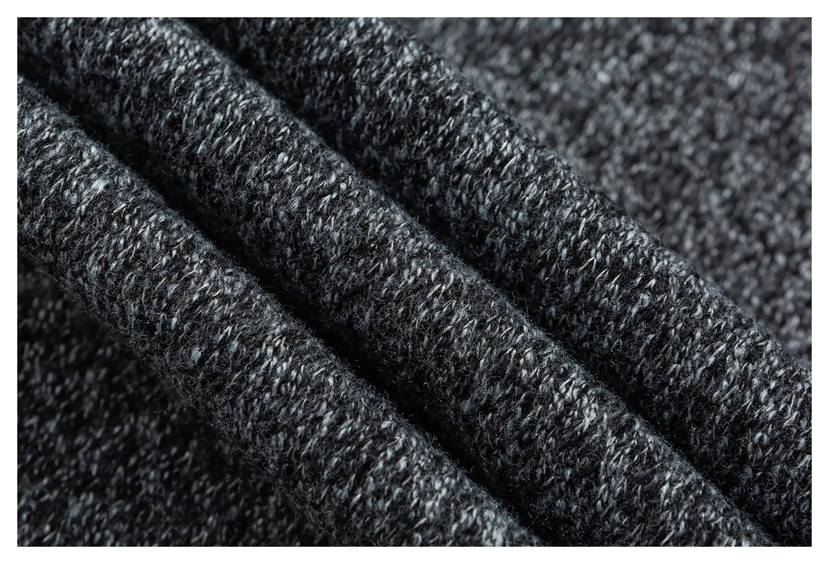 Close-up of dark charcoal knit fabric with a textured, flecked yarn pattern.