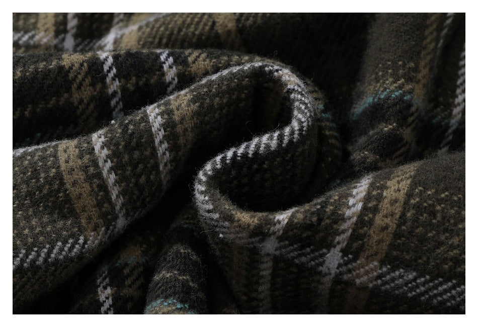 Macro view of the dark brown plaid shirt fabric, showing its fuzzy surface and woven check pattern.