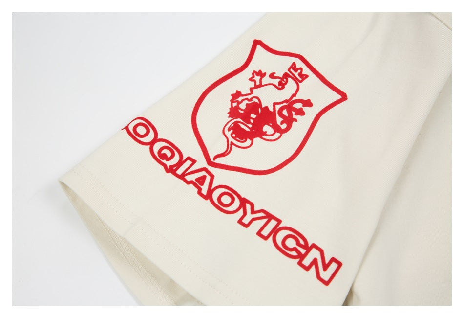 Off-white sleeve detail showing a red printed crest and outlined lettering near the hem.