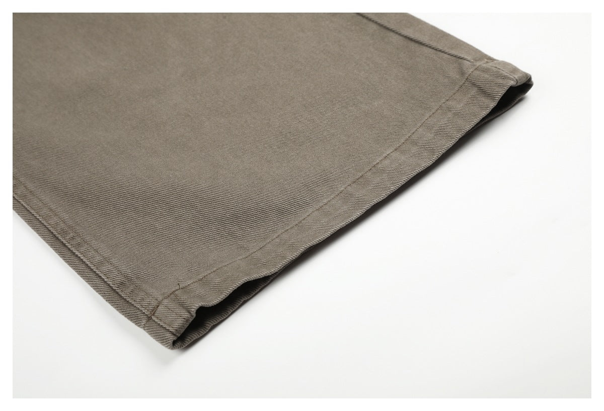 Close-up of the stitched hem on a taupe-gray pant leg.