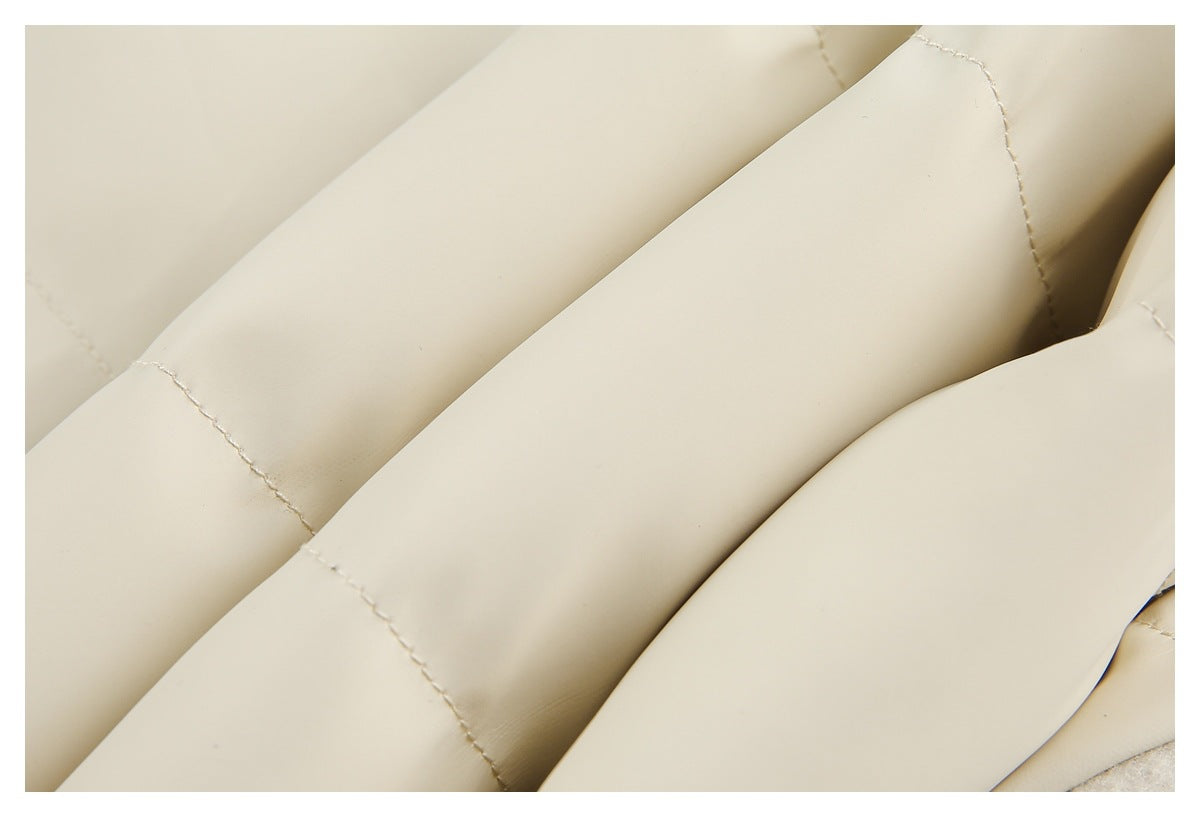 Close-up of overlapping cream garment panels with visible stitching and folded edges.
