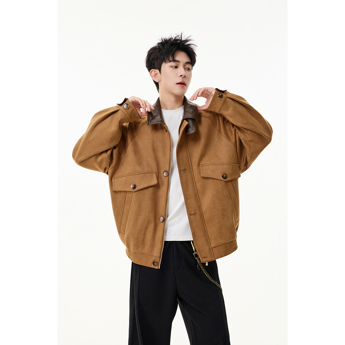 Model wearing an oversized camel-brown jacket with a dark brown collar, buttoned flap pockets, and a front zipper.