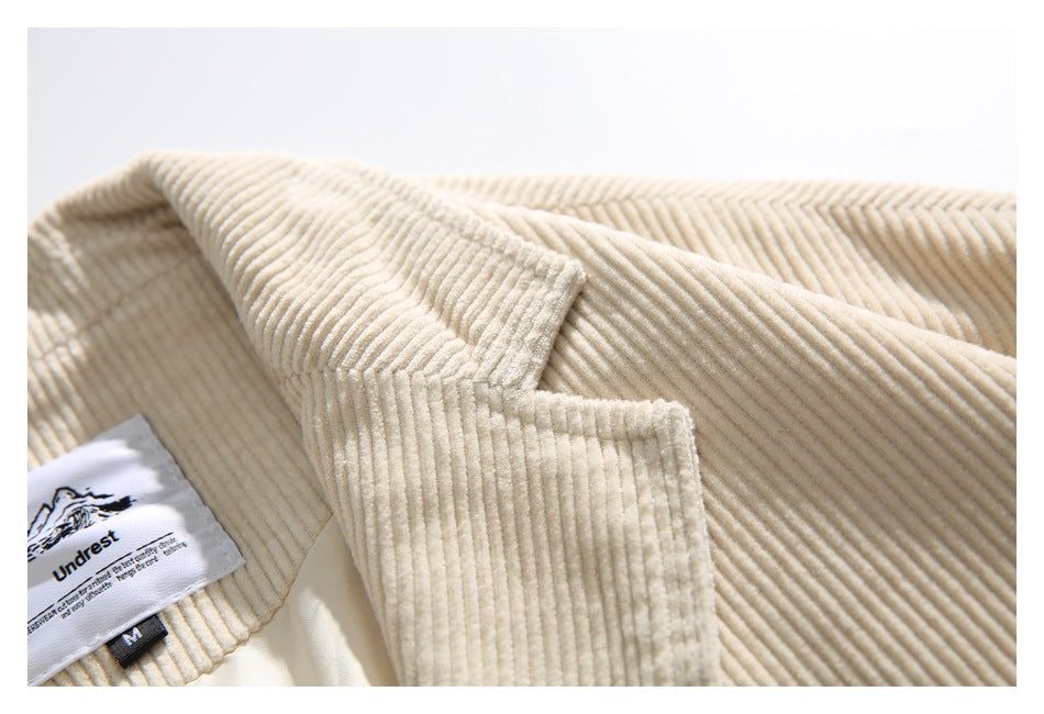 Close-up of the cream corduroy jacket's collar, lapel and sewn-in brand and size labels.