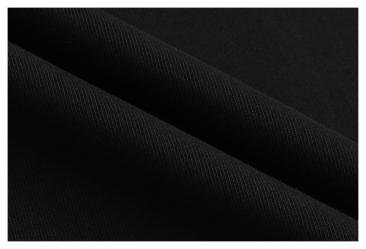Extreme close-up showing the fine knit texture of black fabric folded into ridges.