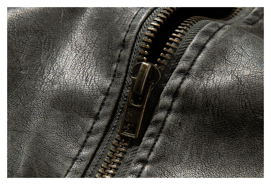Close-up of the jacket's bronze-tone zipper against charcoal gray textured material.