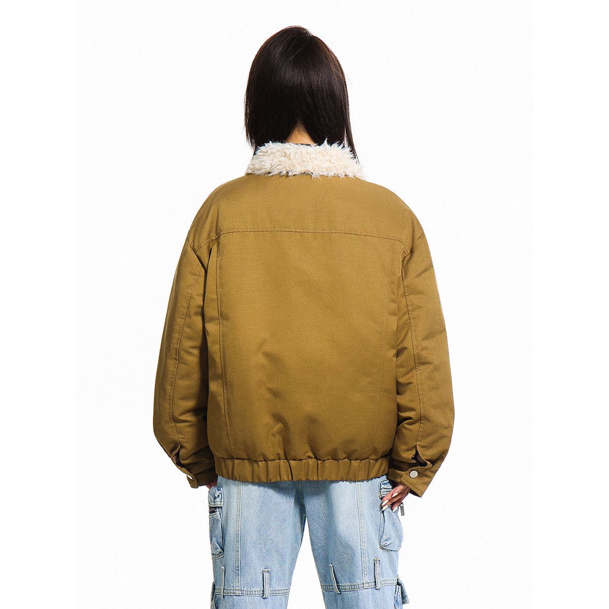 Rear view of an ochre-brown jacket with a cream faux-fur collar and elasticated hem, worn with light-wash cargo jeans.