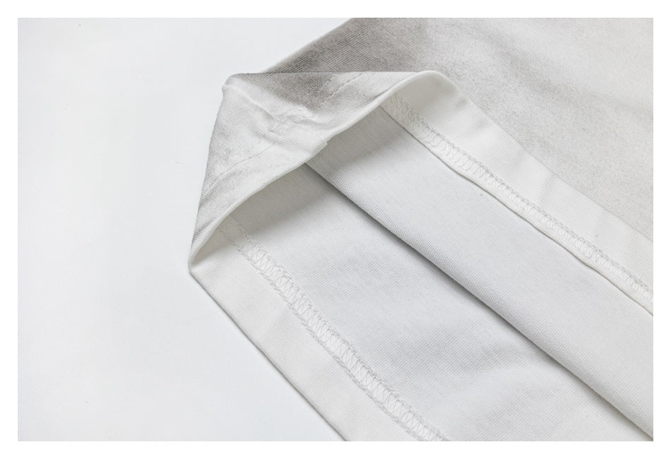 Close-up of folded white garment fabric showing the inside seam stitching.