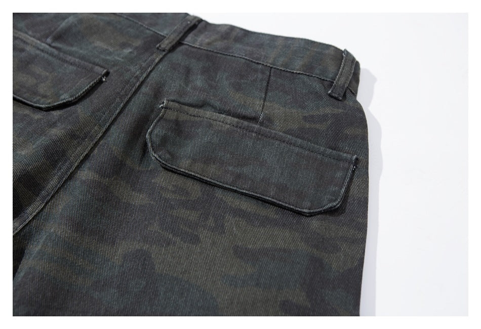 Close-up of the waistband, belt loops, and flap pocket on dark camouflage trousers.